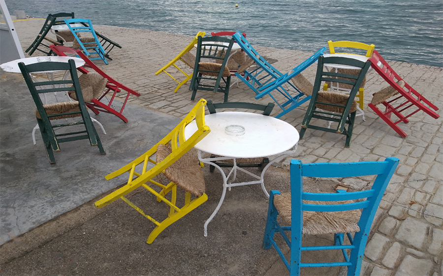Lehre Tische und hochgeklappte Stühle in einem Strandcafé